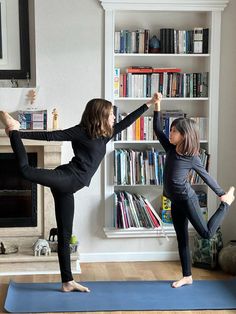 two women doing yoga in front of a bookcase