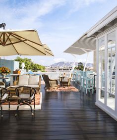 an outdoor deck with chairs and umbrellas