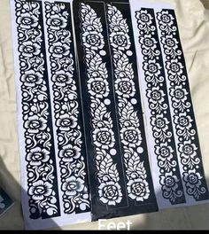 four decorative stencils are sitting on a sheet of white paper with black and white designs