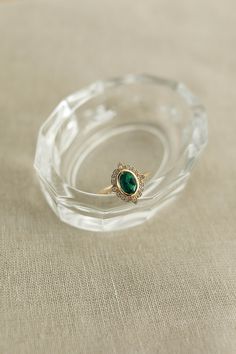 Heirloom Oval Emerald Ring, Elegant Emerald Ring With Oval Cabochon, Classic Emerald Ring With Halo, Classic Round Emerald Ring With Halo, Timeless Oval Emerald Ring With Bezel Setting, Heirloom Style Emerald Ring With Halo For Formal Occasions, Exquisite Oval Emerald Ring With Accent Stones, Heirloom Style Emerald Ring With Halo, Classic Oval Emerald Ring With Bezel Setting