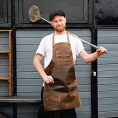 a man wearing an apron and holding a spatula