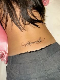 the back of a woman's stomach with her name tattoo on it, in cursive script