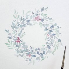 a watercolor painting of a wreath with berries and leaves painted on the wall behind it