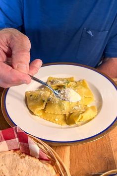 a person is eating some food on a plate with a knife and fork in their hand