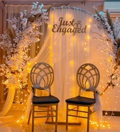 two chairs sitting in front of a backdrop with lights