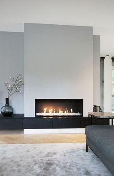 a living room with a couch and a fire place in the middle of the room