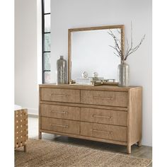 a dresser with a mirror and vases on top of it in a living room