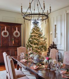 a dining room with a christmas tree in the center and other decorations on the table