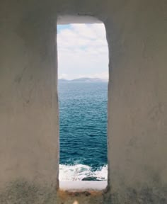 an open window with the ocean in the background