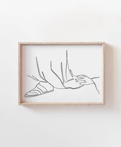 a black and white drawing on a wall next to a framed piece of paper with a hand reaching for something