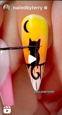 someone is holding a fake nail with a cat on it and the nails have been painted