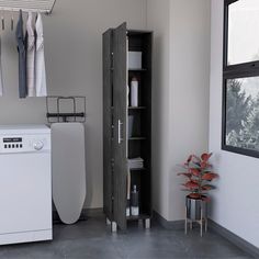 a washer and dryer in a room with clothes hanging on the rack next to it