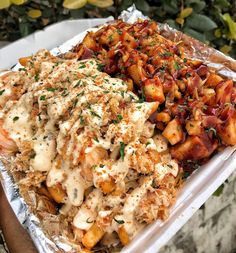 a tray filled with different types of food on top of tin foil covered in sauce