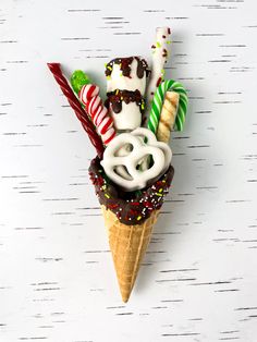 an ice cream cone with assorted candy and candies in it on a white background