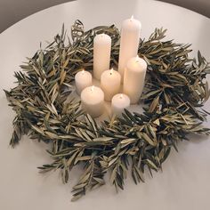 candles are arranged in a wreath on a table