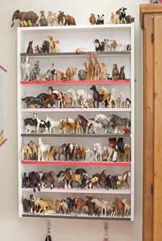 a white shelf filled with lots of toy animals