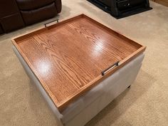 a large wooden table sitting on top of a carpeted floor next to a brown couch