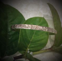 MAKE SURE OF THE SIZE BEFORE ORDERING. 5mm gold filled Hawaiian bangle, 1.70mm thickness. Personalize it with a name or a message engraved and enameled in black. The pattern of plumerias and Victorian scrolls are rolled on a 5mm barrel gold filled wire. All the characters are engraved , not stamped, resulting in straight and aligned name. A black enamel is used to fill in the characters engraved. The maximum number of letters is 15. How Gold filled is made. Gold filled or gold overlay is made by Etched Yellow Gold Bangle For Anniversary, Classic Adjustable Etched Bangle, Adjustable Etched Gold Bangle, Adjustable Gold Etched Bangle, Silver And 14k Gold Cuff Bangle, Silver 14k Gold Cuff Bangle Bracelet, Gift Gold Etched Cuff Bracelet, Ceremonial 14k Gold Engraved Bangle, Adjustable Etched Bangle For Ceremonial Occasions