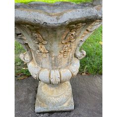 a stone vase sitting on top of a cement slab