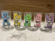 four glasses with different colored teddy bears on them