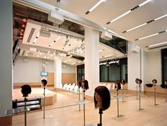 a group of people standing around in a room with chairs and lights on the ceiling