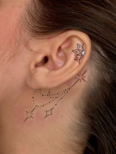 a woman's ear has a tattoo on it