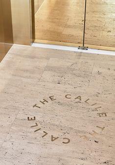 the entrance to an art gallery with words carved into it's walls and floor