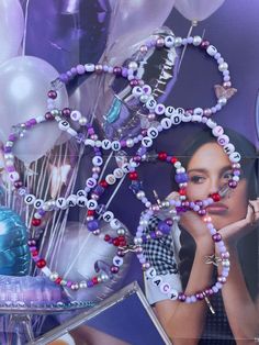 a woman is surrounded by balloons and beads