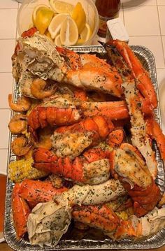 lobsters and crab legs on a tray with lemon wedges