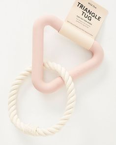 a pink and white object on a white surface next to a tag that says triangle tug