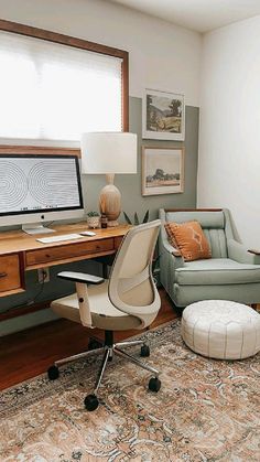 a home office with a chair, desk and computer on top of a rug in front of a window