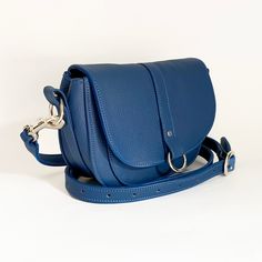 The 'Christie' crossbody handbag is individually handcrafted in our South Devon workshop.   It is made from Royal Blue Italian leather, featuring solid nickel plated brass fittings with a magnetic fastening under the flap. This bag features a small pocket on the front of the bag and is lined with a blue and white floral Liberty of London cotton fabric. It has a fully adjustable belt style strap. Why not add a complimentary personalised label to the lining?  Your message will be printed onto a wh Everyday Satchel Flap Bag With Palladium Hardware, Classic Saddle Bag With Silver-tone Hardware For Everyday, Everyday Crossbody Satchel With Palladium Hardware, Leather Saddle Bag With Silver-tone Hardware, Leather Saddle Bag With Silver-tone Hardware For Everyday Use, Everyday Flap Bag With Palladium Hardware, Classic Everyday Flap Bag With Silver-tone Hardware, Classic Flap Bag With Silver-tone Hardware For Everyday Use, Everyday Satchel Saddle Bag With Metal Hardware