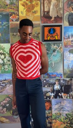 a man standing in front of a wall with paintings on it