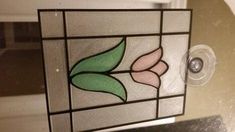 a close up of a stained glass window with a flower design on the bottom half