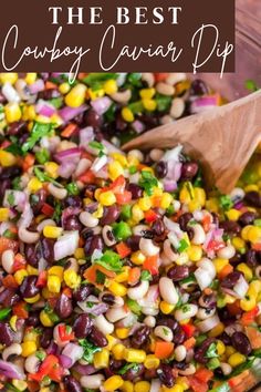 a wooden spoon in a bowl filled with beans and veggies