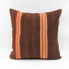 a brown and orange striped pillow on a white background