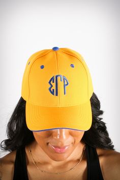 a woman wearing a yellow and blue hat with the letter p on it's peak