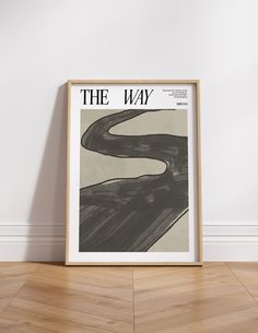 the way poster in front of a white wall with wood flooring and wooden framed artwork