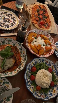 a table topped with lots of plates and bowls filled with different types of pizzas