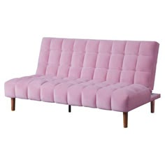 a pink futon sofa with wooden legs