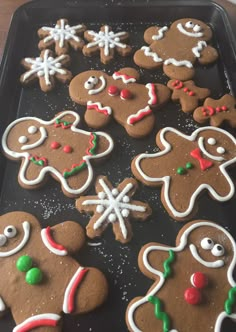 there are many decorated ginger cookies on the baking sheet