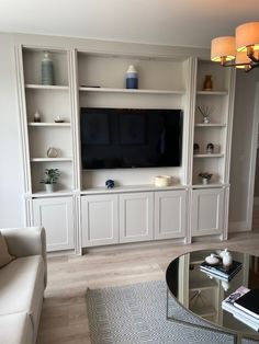 a living room filled with furniture and a flat screen tv on top of a wall