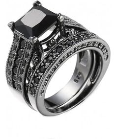 a black diamond engagement ring set on top of each other with two rows of diamonds around the band