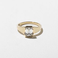 a gold ring with an emerald cut diamond