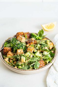 a salad with broccoli and tofu in a bowl