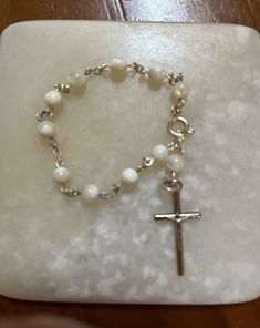 This listing is for a lovely mother-of-pearl rosary bracelet. The beads are in excellent condition. No marking on this piece. Has a spring ring closure. This bracelet is so one can pray a decant of the rosary. 10 Hail Marys, 1 Our Father.) The shipping weight will be 2 ounces. Pearl Rosary, Rosary Bracelet, Our Father, The Rosary, Man Den, Prayer Beads, Spring Rings, Rosary, Vintage Silver