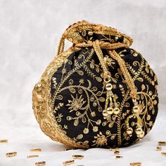 Black Potli Bag with Pearl Handle Strap With its classy zari work and a pearl handle strap all in gold this Black Potli Bag is ideal for this wedding season. Fabric Raw Silk Color Black Embroidery Zari Work in Gold Size amp Dimensions Height - 8 inWidth - 7.5 inDepth - 1.5 in Strap Pearl Handle Strap Closure Tasseled Drawstring Compartments Single compartment Care Wipe with a soft clean amp dry cloth to remove dust When not in use store it in a dust bag for longer product life Avoid liquid expos Gold Handwork Potli Bag For Evening, Gold Potli Bag With Zari Work For Evening, Evening Gold Potli Bag With Zari Work, Traditional Black Evening Bag, Traditional Black Formal Bag, Gold Embroidered Potli Bag For Gift, Traditional Evening Potli Bag With Latkans, Handmade Potli Bag For Party And Festivals, Bollywood Style Embroidered Evening Potli Bag