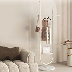 a living room with a white couch and coat rack on the wall next to a coffee table