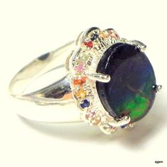 This Awesome Gemstone is a Rare find. It is called Ammolite, and was a fairly recent discovery, found in the depths of the earth in Canada. This is a 10mm x 14mm, oval shaped triplet, set in an Awesome Sterling Silver Ring Setting, with multi-colored, Fancy Sapphire accents. This Beautiful stone, discovered by accident, around 25 years ago, is the petrified shell of a million year old snail. Coveted by collectors, this stone has a glowing property, the likes of which has never been seen until it Fancy Sapphire, Red Orange Yellow, Silver Work, Ring Setting, Color Stone, Antique Items, Orange Yellow, Sterling Silver Ring, Ring Sets