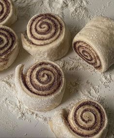 cinnamon rolls are arranged on top of flour